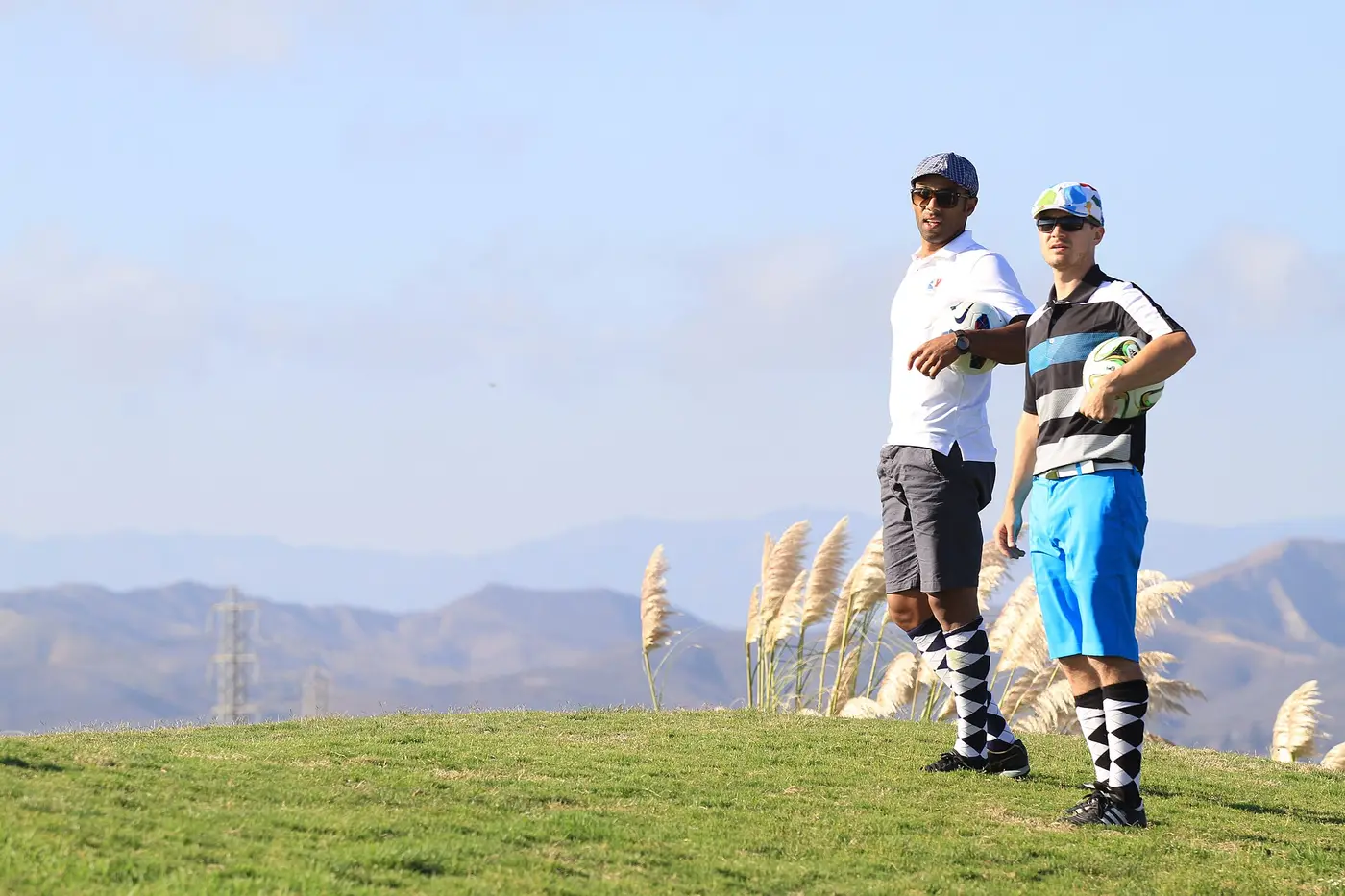 Dos jugadores en la cancha con montañas de fondo